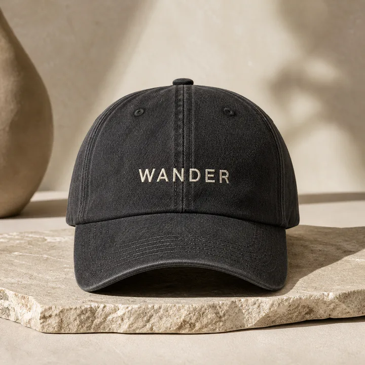 Charcoal cap embroidered with a custom cream wordmark